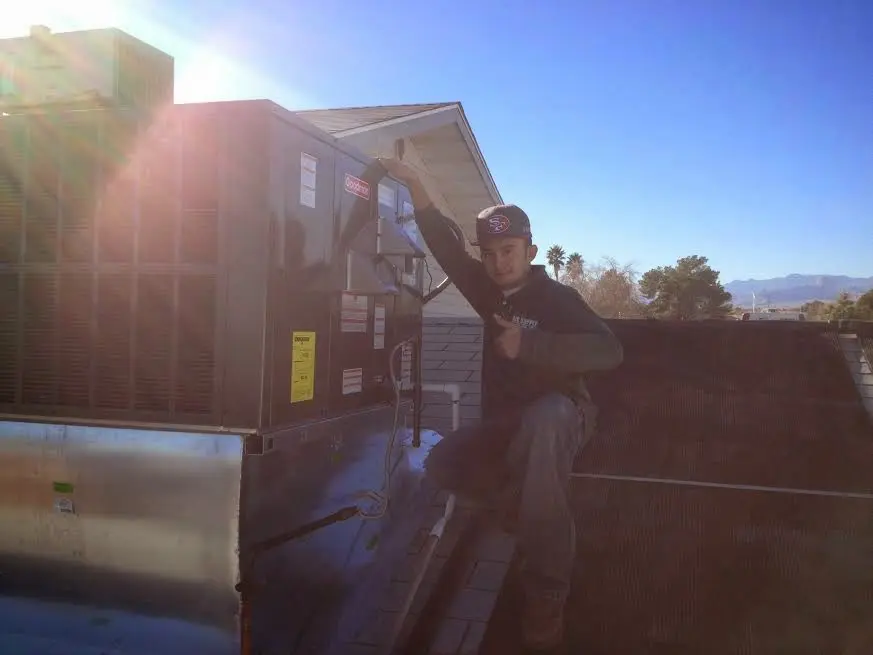 HVAC technician performing Heat Pump Repair on a rooftop unit in Byron